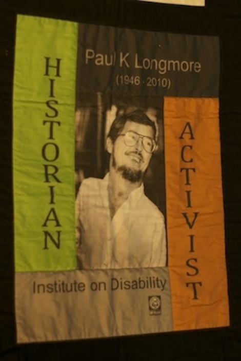 The center block of the Paul K Longmore T-shirt Quilt features a smiling, younger Paul, framed by the words "historian" and "activist."