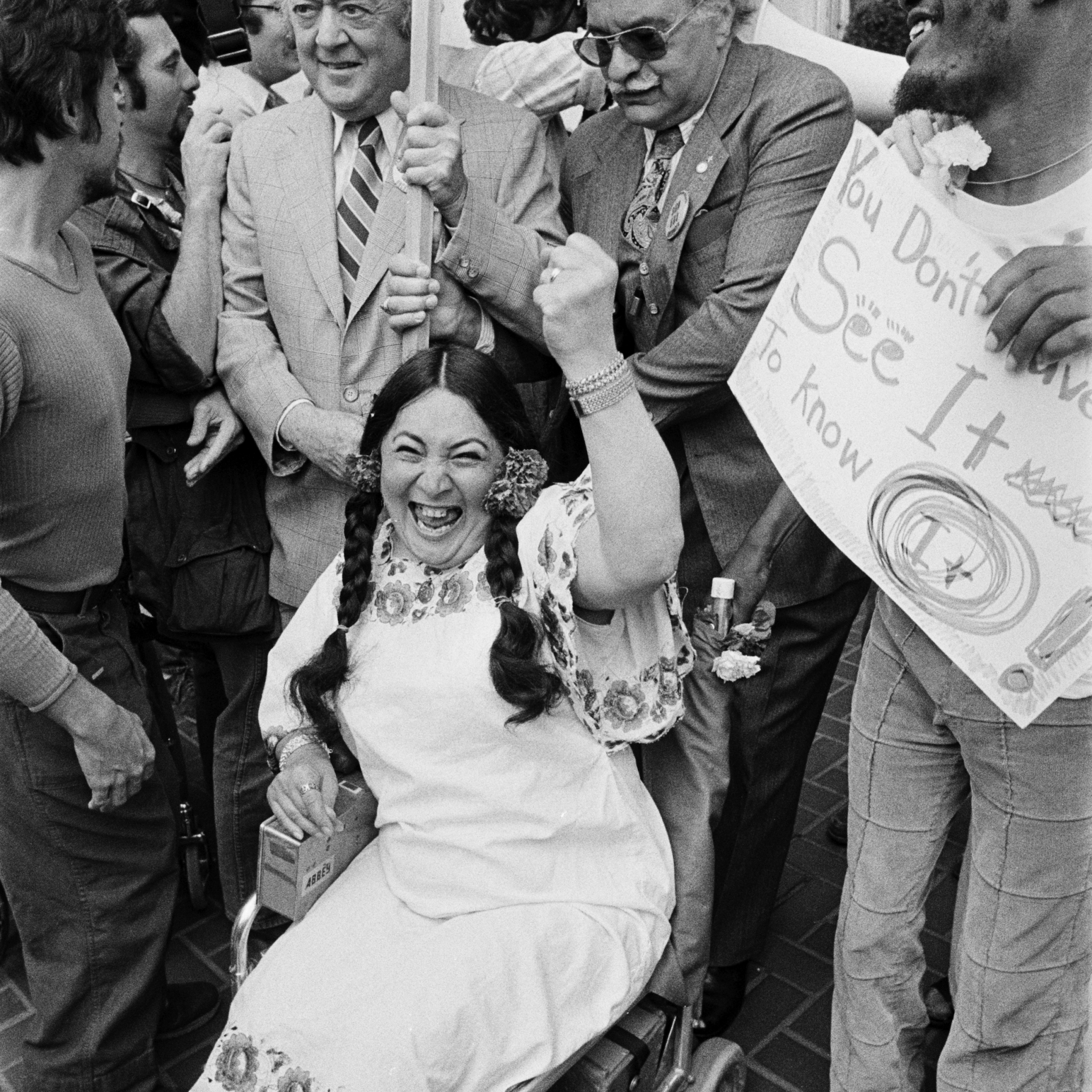 Woman in wheelchair with fist up celebrating